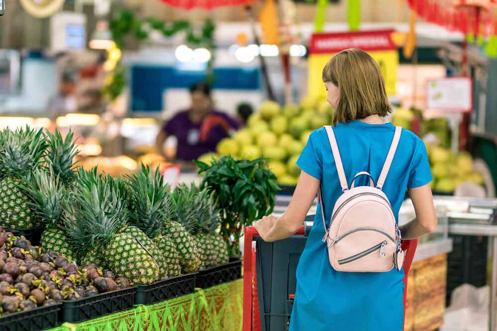 woman-standing-beside-pineapple-fruits