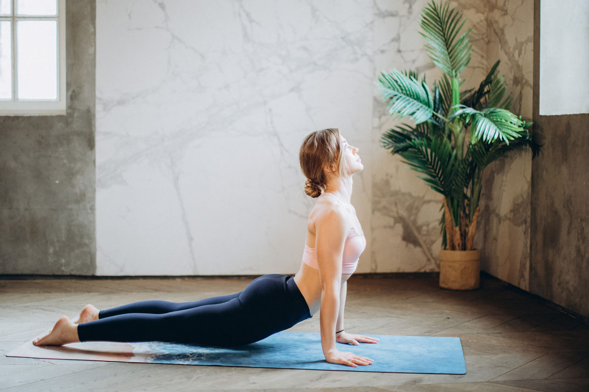 woman-in-pink-sports-bra-and-black-leggings-doing-yoga