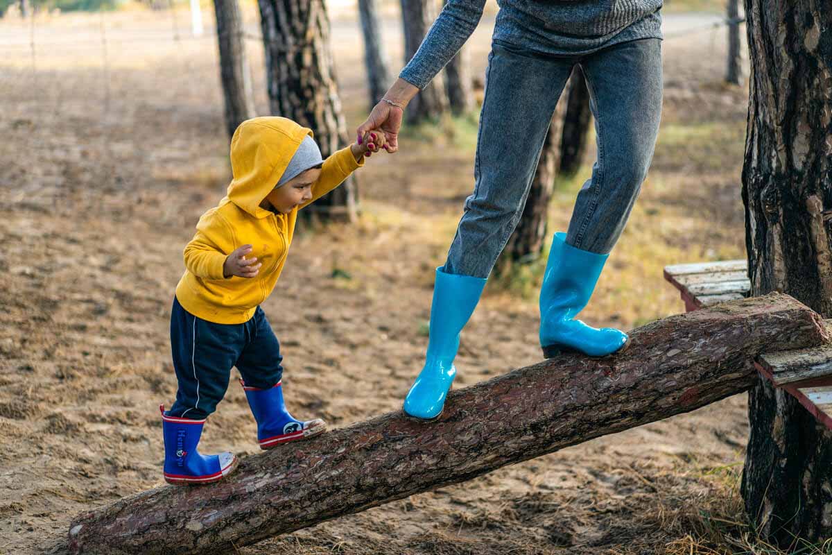 niño de la mano subiendo un árbol